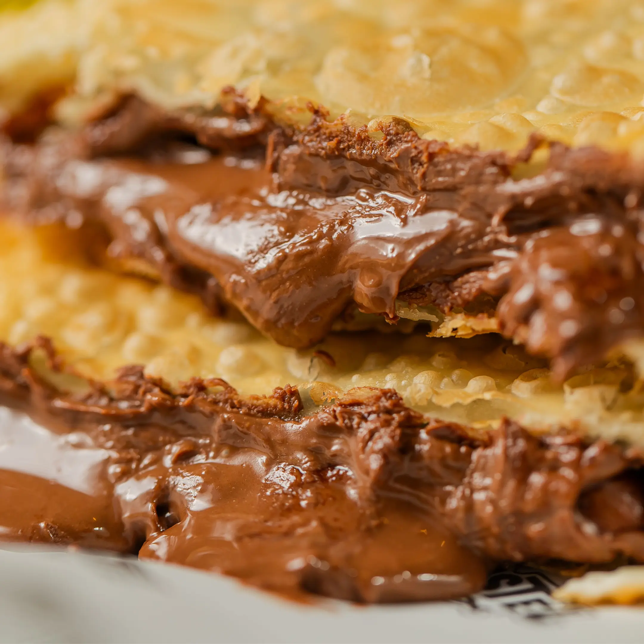 Fotografia focando no recheio generoso do pastel de nutella com chocolate ao leite do Pastel Mix.